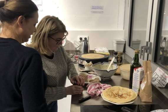 Coopératrices faisant des crêpes dans la cuisine coopérative de la Coop 14